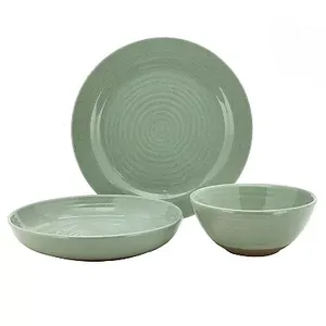 A set of sage green, textured stoneware dinnerware consisting of large plates, smaller plates, and bowls with a visible brown rim at the base.