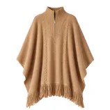 A camel-colored poncho featuring a cable knit design, high collar with a partial zip, and fringed hem.
