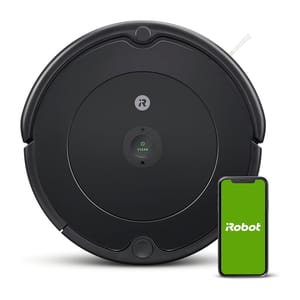 A black Roomba 694 robotic vacuum cleaner is shown next to a smartphone with the iRobot logo on its screen, depicting compatibility with the app for control.