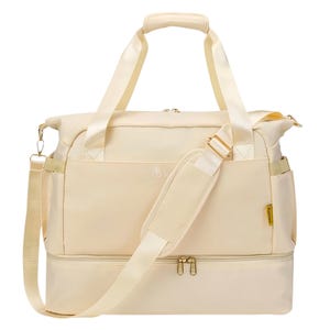 Beige travel bag with dual handles, adjustable shoulder strap, and a separate zippered bottom compartment.