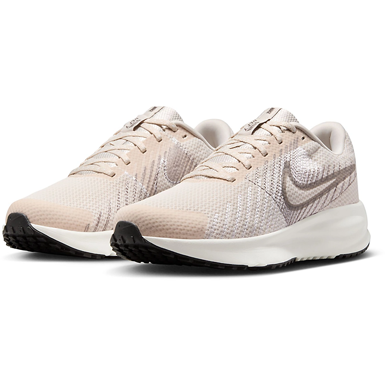 Beige and white Nike running shoes with a mesh upper, subtle swoosh design, and black soles.