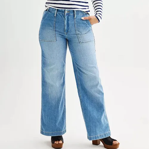 A person wearing light blue wide-leg jeans and brown platform sandals.