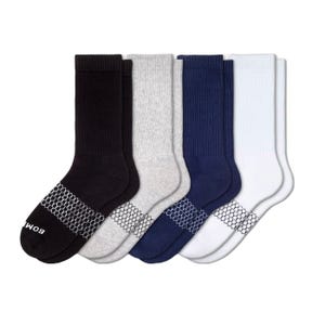 A set of four pairs of crew socks in black, gray, navy, and white with honeycomb patterns on the soles.