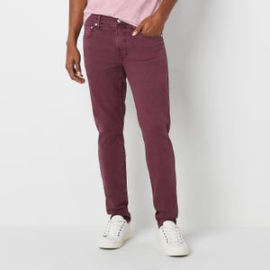 A person is wearing burgundy jeans and white sneakers.