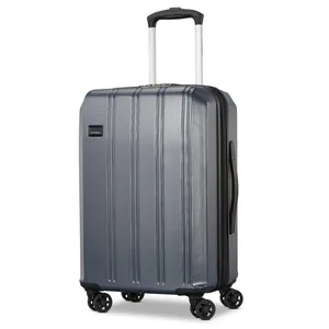 A gray hard-shell suitcase with a retractable handle and four double spinner wheels, featuring a textured surface and a side handle.
