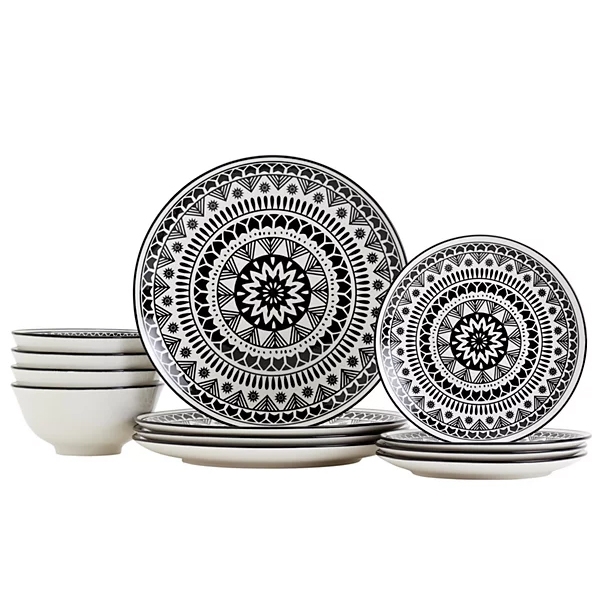 A set of ceramic dinnerware featuring plates and bowls with intricate black and white geometric patterns.