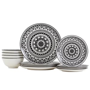 A set of ceramic dinnerware featuring plates and bowls with intricate black and white geometric patterns.