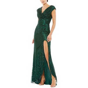 An elegant green sequin evening gown featuring a V-neckline, cap sleeves, and a thigh-high slit, paired with strappy heels.