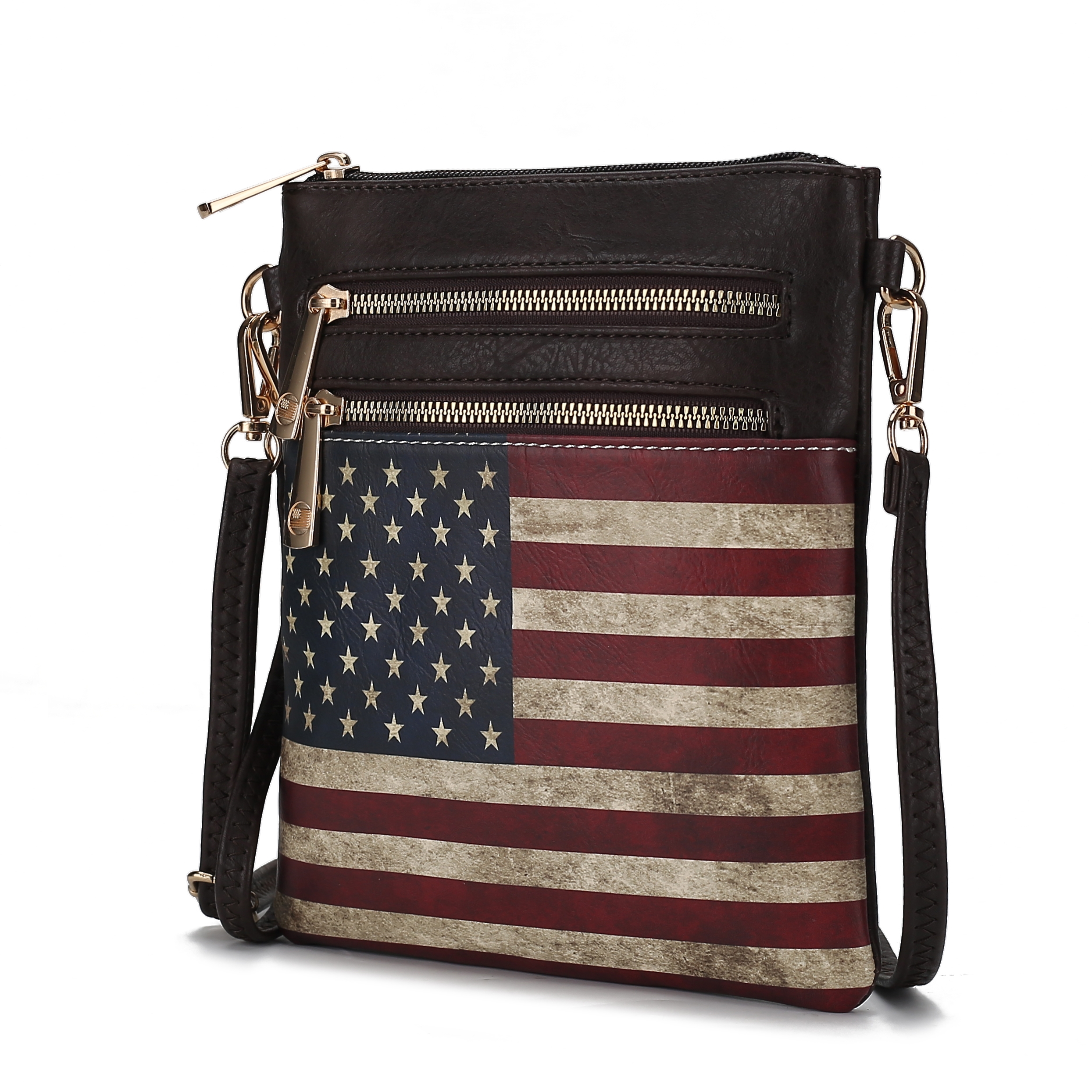 A crossbody bag with a dark leather design featuring a large U.S. flag print and multiple gold zippers, complemented by a detachable strap.
