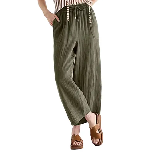 Woman wearing olive green, wide-leg pants with a drawstring waistband, paired with a striped top and brown platform sandals.
