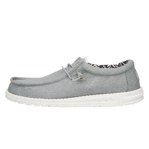 Gray slip-on shoes featuring a soft canvas upper, elastic laces, and a cushioned white sole with speckles. The interior has a patterned lining providing a casual and comfortable look.