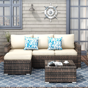 The 3pc Modular Patio Sofa Set includes a sectional sofa with beige cushions, a matching coffee table, and two blue floral throw pillows on a patterned outdoor rug, all set against a nautical-themed wall with a ship's wheel decoration.