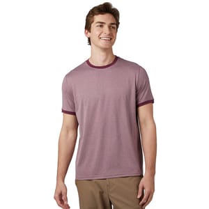 A man wears a 32 Degrees Ringer Tee in heather red with contrasting burgundy trim on the collar and sleeves. The shirt is short-sleeved, and he pairs it with khaki pants.