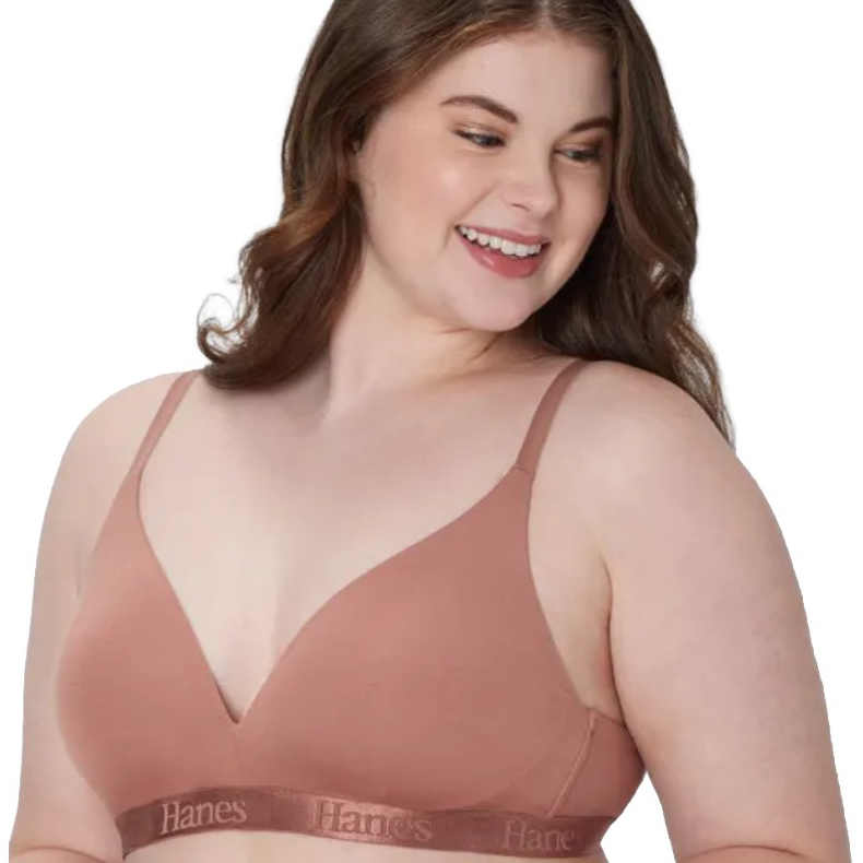 A woman is wearing a Hanes branded bra in a nude color, featuring a seamless, wire-free design with adjustable straps.