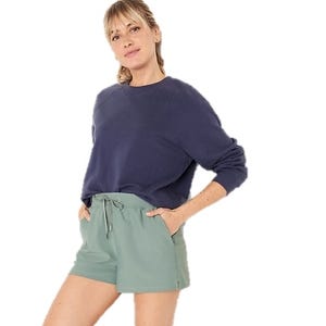 High-rise, light green shorts with a drawstring waistband and side pockets, offering a relaxed fit and casual look.