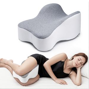 A contoured knee pillow designed for side sleepers to provide leg support and improve spine alignment. It has a gray and white color scheme and is shown in use by a person lying on their side.