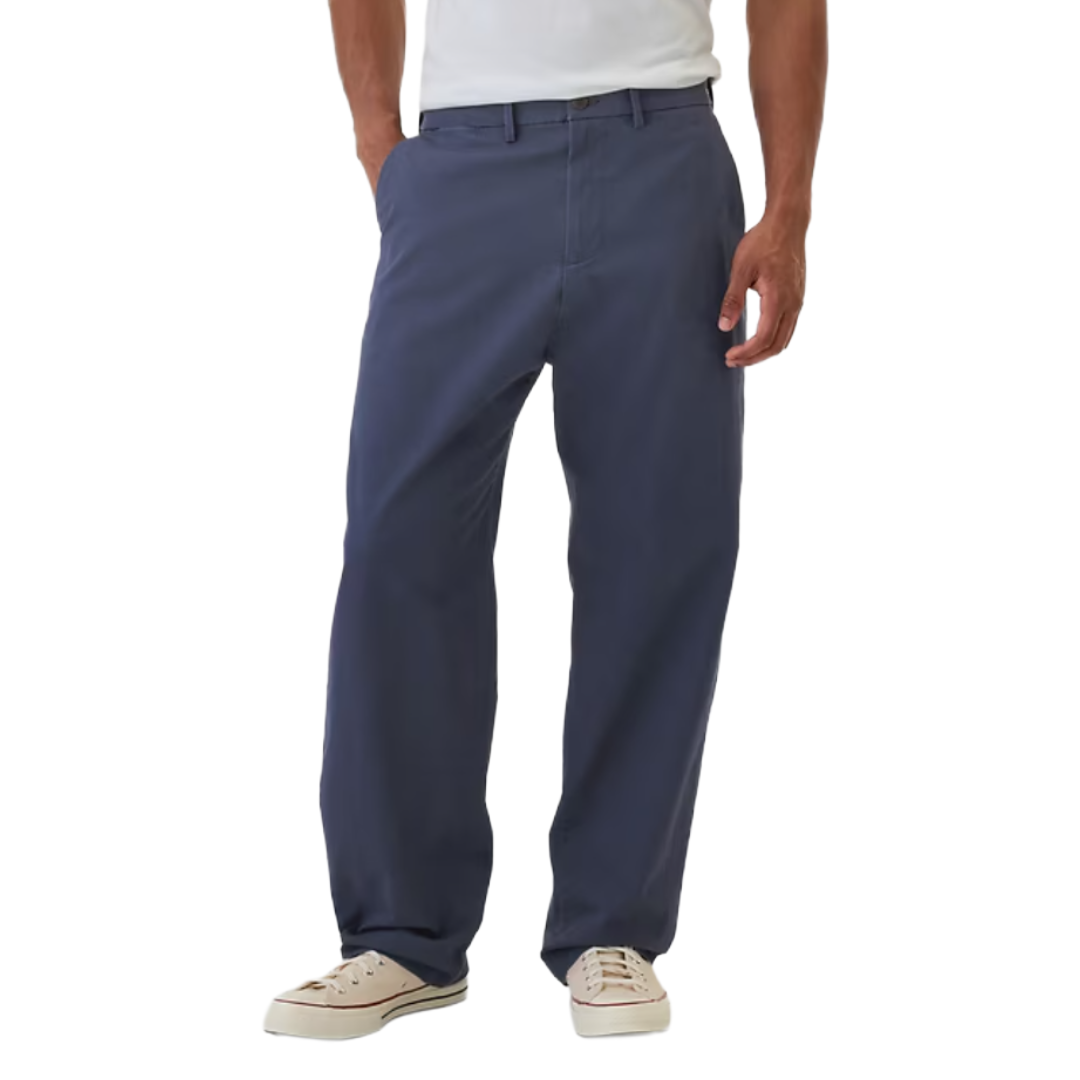 Man wearing navy blue straight-leg pants and white sneakers, featuring a simple design with belt loops and side pockets.