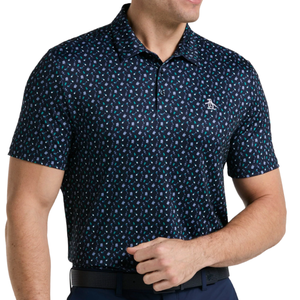 A man is wearing a dark patterned polo shirt with a penguin logo on the chest, paired with dark pants and a black belt.