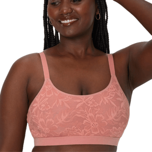 A woman is wearing a soft pink Bali Breathe Bralette featuring floral lace detail, adjustable straps, and a comfortable band.