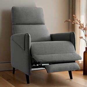 A gray upholstered recliner with a tall backrest and padded armrests, featuring a footrest that extends outward for added comfort, set on a sleek wooden floor near a window with sheer curtains.