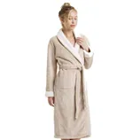 A woman is modeling a beige fleece bathrobe with white sherpa trim, featuring a tie belt and pockets.