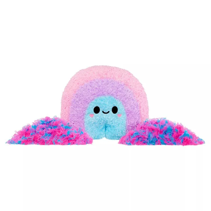 A colorful plush toy shaped like a smiling rainbow with pink, purple, and blue hues, accompanied by two piles of matching fluffy material.