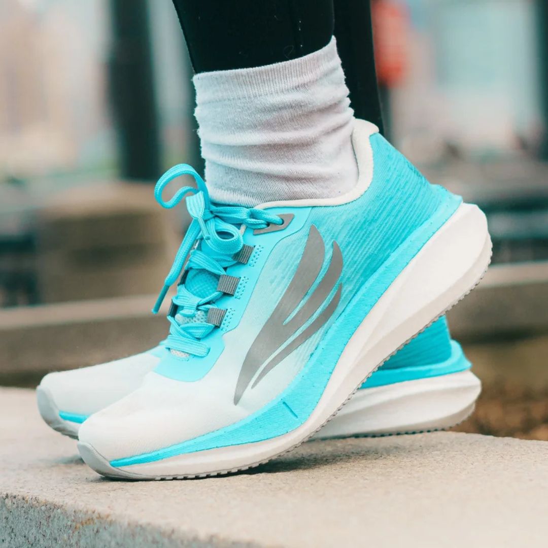 Bright turquoise athletic shoes with gray accents, worn with white socks.