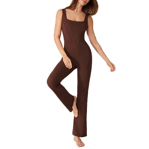A brown, sleeveless, form-fitting jumpsuit with a square neckline, extending to the ankles, shown on a person standing with one leg slightly raised.