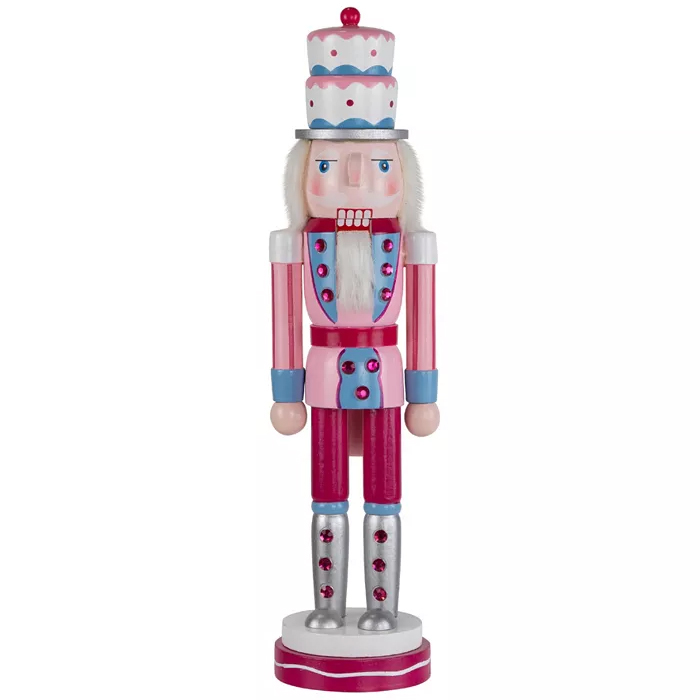 A colorful nutcracker figure with a pink, blue, and white color scheme, featuring a tall hat, beard, and shiny silver boots.