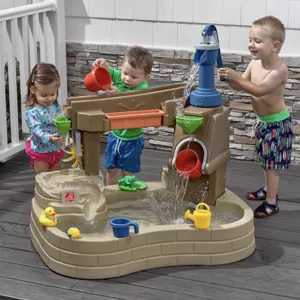 Children playing with a water activity table featuring a pump, buckets, and various water toys like rubber ducks and watering cans, designed for outdoor fun.