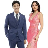 A man in a blue suit with a floral tie stands next to a woman wearing a sleeveless, pink sequin gown with a thigh-high slit.