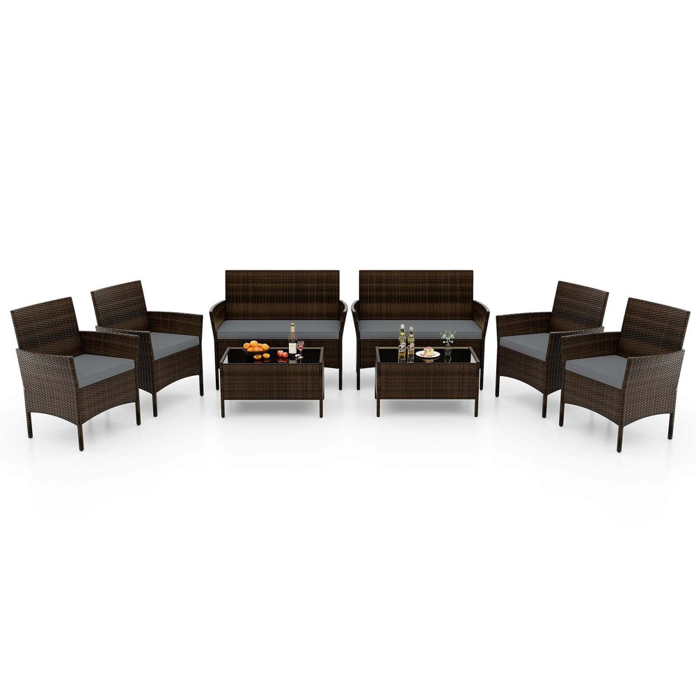 8-piece Costway patio set includes four armchairs, two loveseats, and two coffee tables, all in dark brown synthetic rattan with black glass table tops. Each seating piece has cushions for comfort.