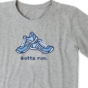 A gray T-shirt featuring an illustration of blue sneakers with white stripes and the text \“Gotta run.\“