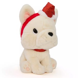 A plush toy resembling a white bulldog wearing a red and white Santa hat and a red glittery collar.