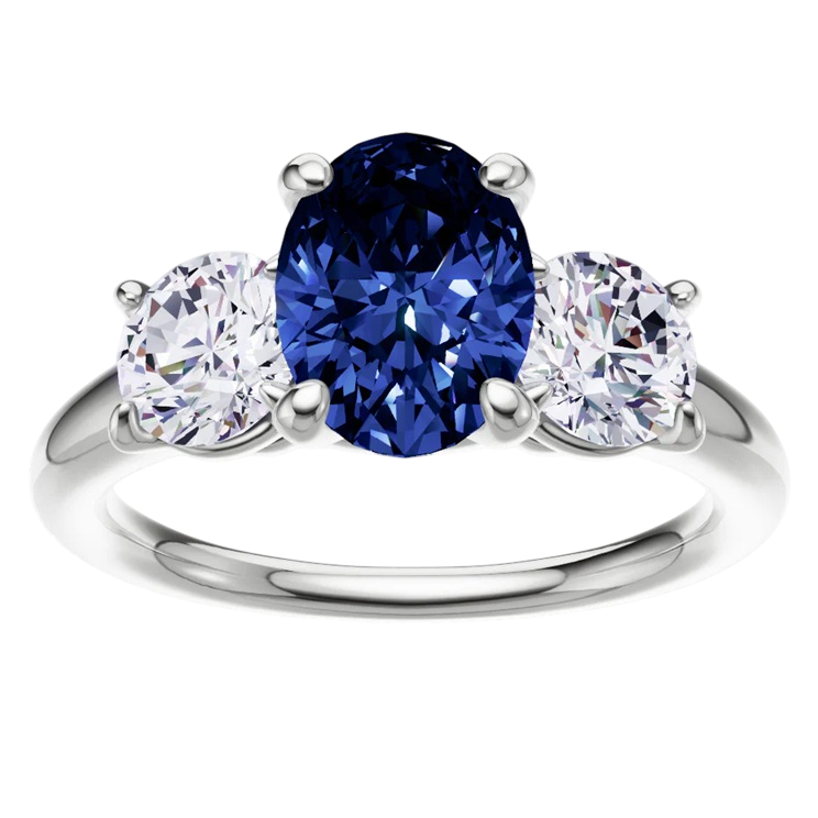 A ring features a large, oval blue sapphire flanked by two smaller round diamonds, all set in a shiny metal band.