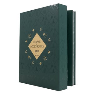 Aldo X Wicked 12 Days of Accessories Box features a dark green design with golden crescent moons and stars. The box promises a collection of accessories themed around \“Wicked,\“ associated with Aldo.
