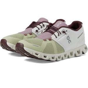 A pair of light green and purple running shoes with a distinctive sole design.