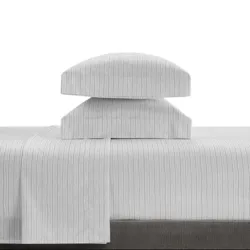 A stack of two pillows covered in white fabric with subtle vertical pinstripes, placed on a matching pinstriped bedsheet.