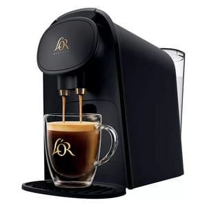 A black L'OR Barista coffee machine is shown with a glass mug filled with coffee, featuring the L'OR logo on both the machine and mug.