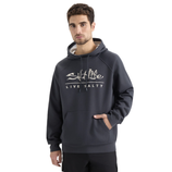 A man is wearing a dark grey hoodie with the text \“Salt Life Live Salty\“ printed on the front. The hoodie features a drawstring hood and a front pocket.
