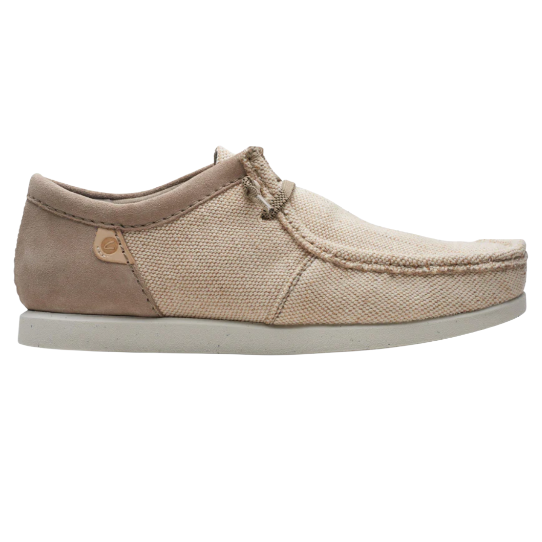 A casual beige slip-on shoe with a textured fabric upper, moc toe design, and a cushioned white sole.