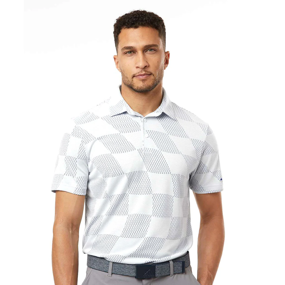 Man wearing a short-sleeve checkered polo shirt in white with blue accents and light gray pants, accessorized with a dark blue belt.