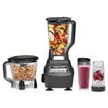 Ninja blender set with a large pitcher filled with fruits, a food processor, and two smoothie cups, one with a pink smoothie and another with berries.