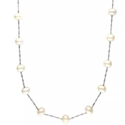 A delicate necklace featuring evenly spaced white pearls on a twisted silver chain.
