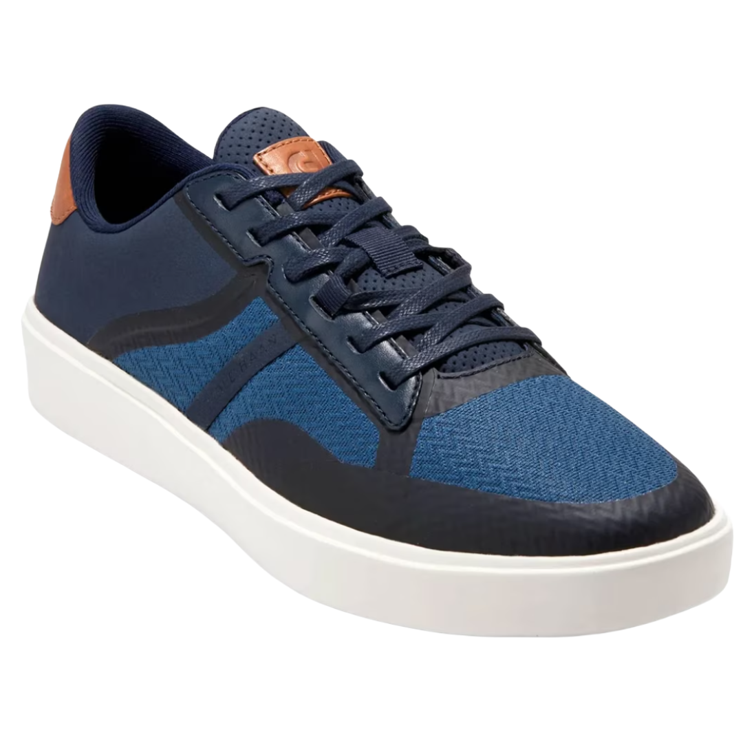 A blue sneaker with a textured pattern, featuring dark blue overlays, brown accents, and a white sole.