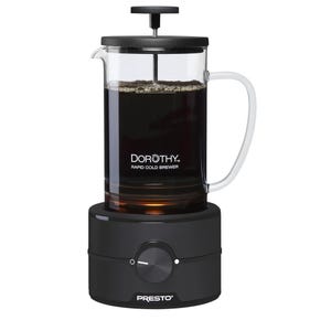 Presto Dorothy Rapid Cold Brewer features a glass carafe with a black handle and lid, equipped with a plunger mechanism and a black base with a central dial, designed for quickly brewing cold coffee.
