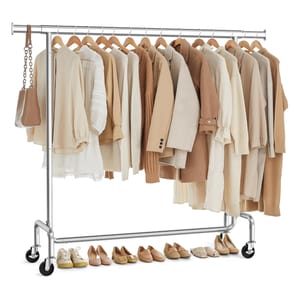 A clothing rack displays neutral-toned garments including blouses, jackets, and sweaters, accompanied by a small handbag. Various shoes are lined up beneath, featuring flats, loafers, and sneakers in matching neutral shades.
