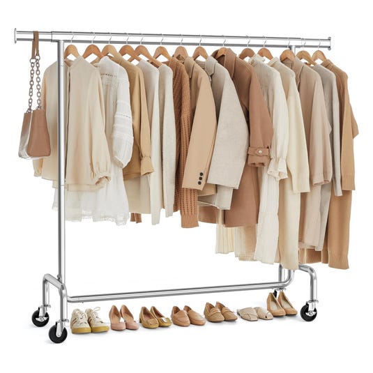 A clothing rack displays neutral-toned garments including blouses, jackets, and sweaters, accompanied by a small handbag. Various shoes are lined up beneath, featuring flats, loafers, and sneakers in matching neutral shades.