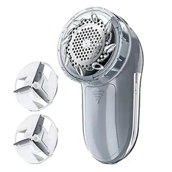 Electric fabric shaver with two replacement blades, designed for removing lint and fuzz from clothing and textiles.