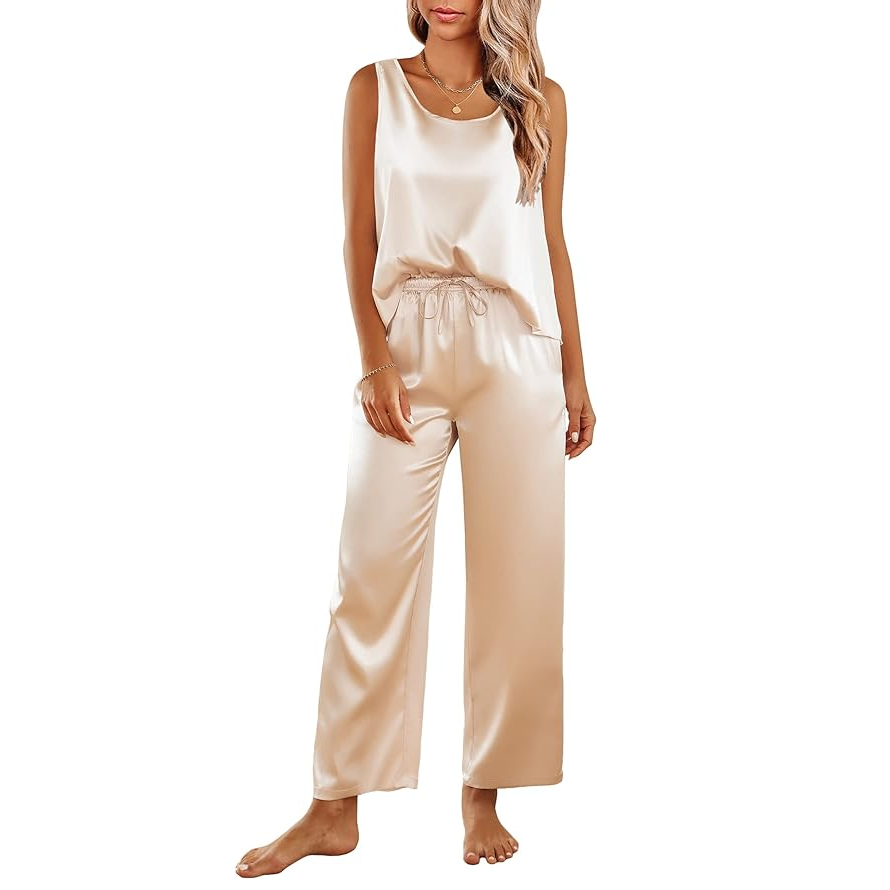 A woman models a sleeveless, cream-colored satin jumpsuit with a drawstring waist.